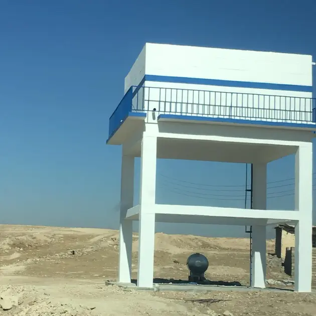 A newly constructed water tower in a barren landscape, providing water storage for the surrounding area.