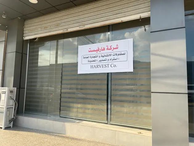 Storefront of Harvest Co. with signage in Arabic and English.